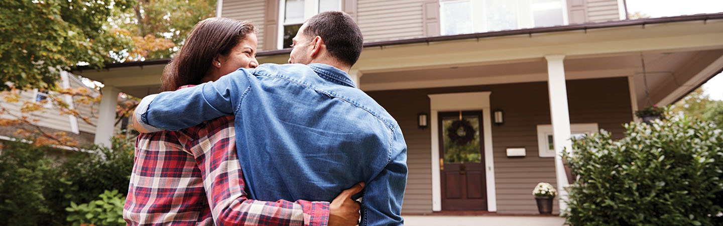 A couple walking to the front porch of their home