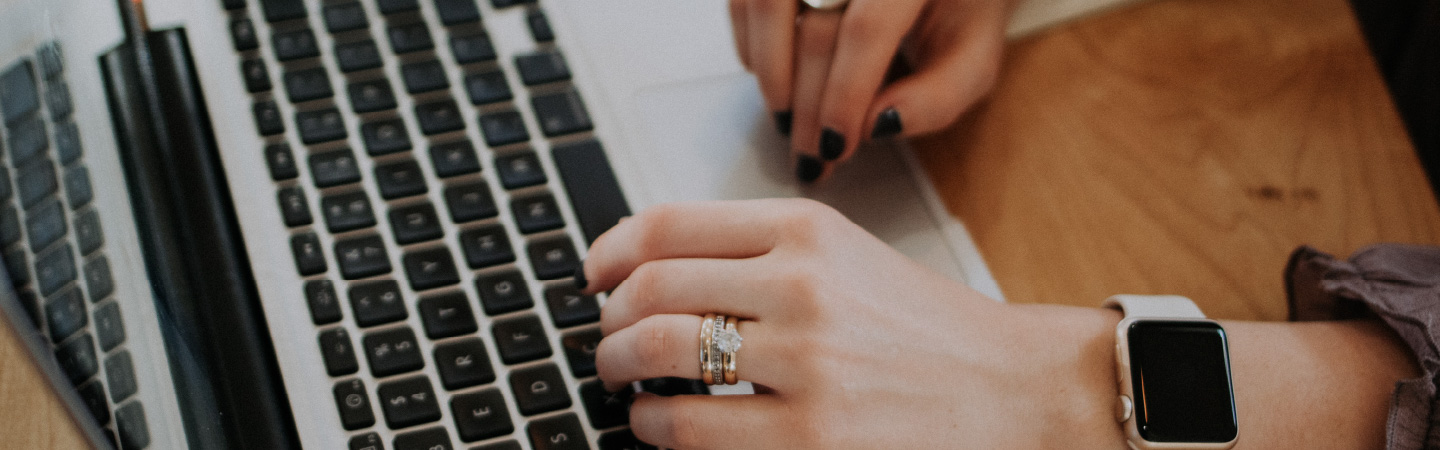 Close up of a person's hands over a laptop keyboard.