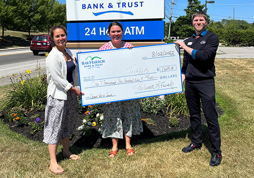 BHBT employees present a check to Trekkers