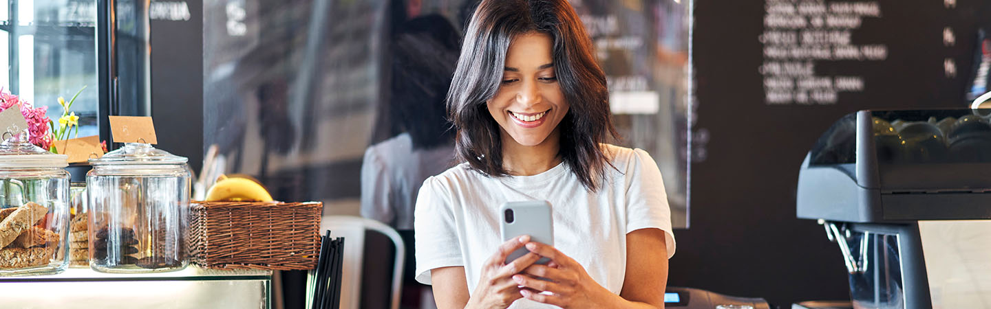 A woman checking her mobile phone in a cafe