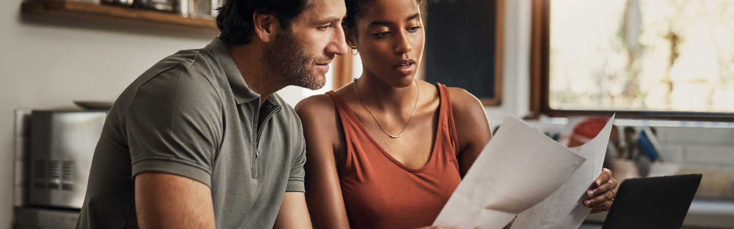 A couple looking over paper mail together.