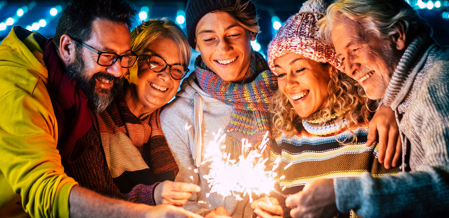 People smiling and lighting sparklers
