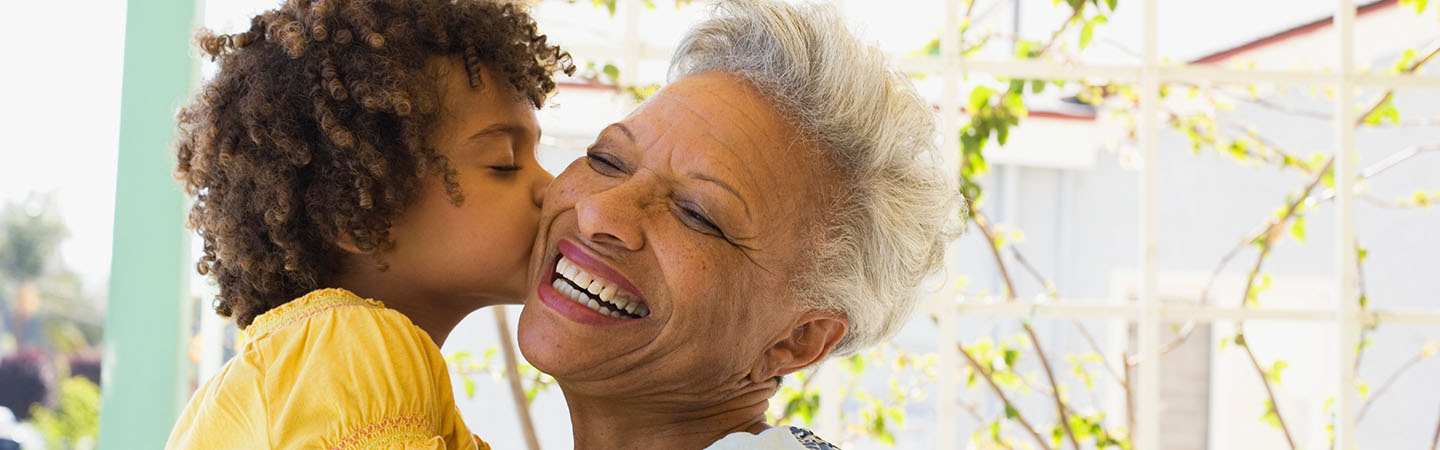 Older woman getting a kiss from grandchild