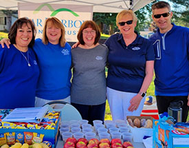 BHBT employees smiling while volunteering at race stop