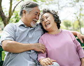 Older couple sitting on an outside bench