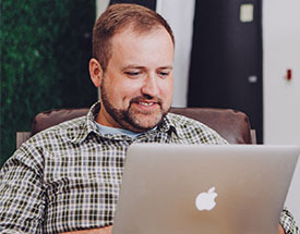 Man smiling while looking at laptop