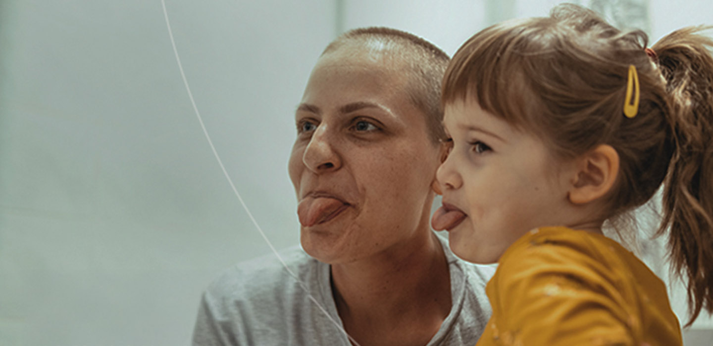 Woman and little girl stick their tongues out