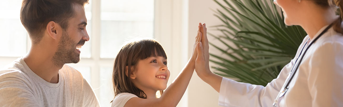 Young girl giving a high five to her doctor