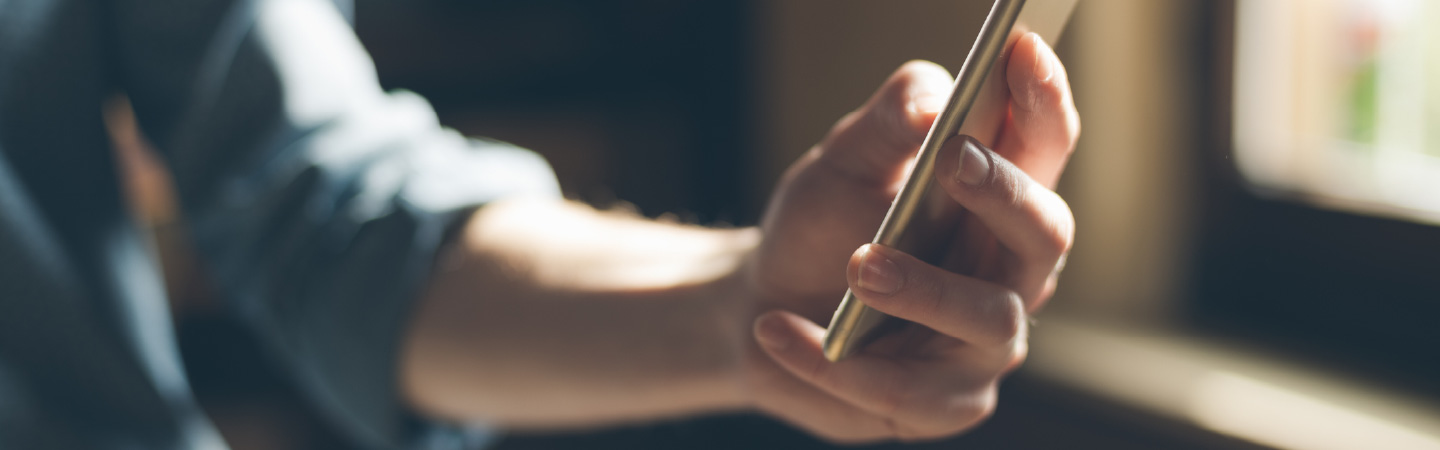 Close up of a person's hands using a smartphone.