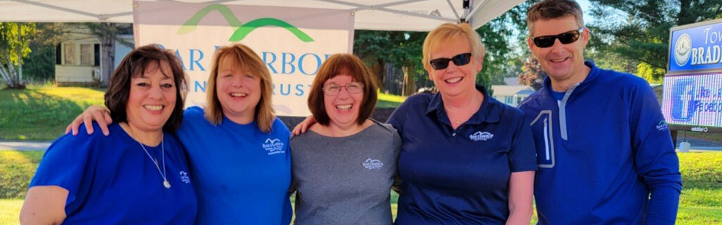 BHBT employees smiling while volunteering at race stop
