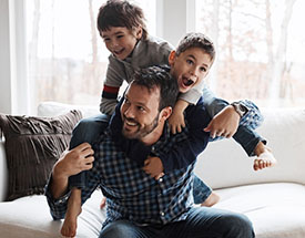 A father and two sons laughing at home
