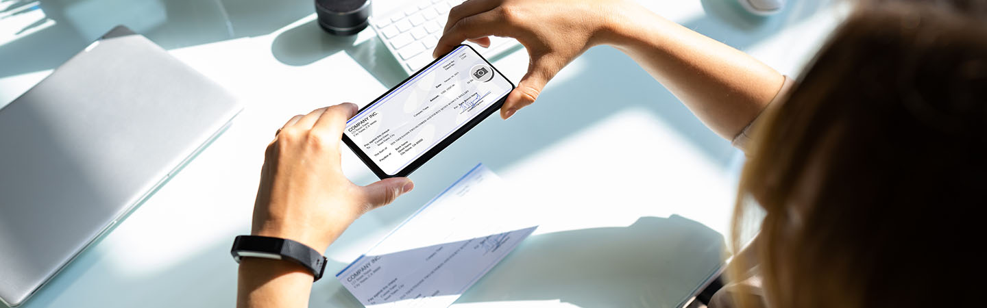 Someone taking a photo of a check with her smartphone