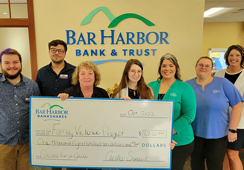 BHT employees present a check to Family Violence Project