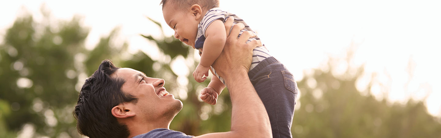 Man holding up his infant son