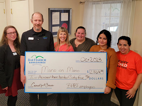 BHBT employees present a donation to Mano en Mano