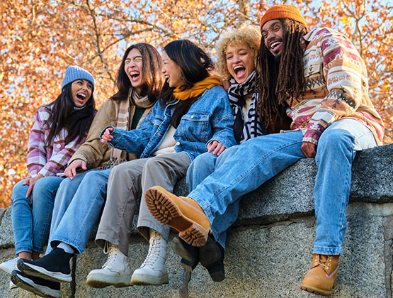 Friends laughing while surrounded by Fall foliage