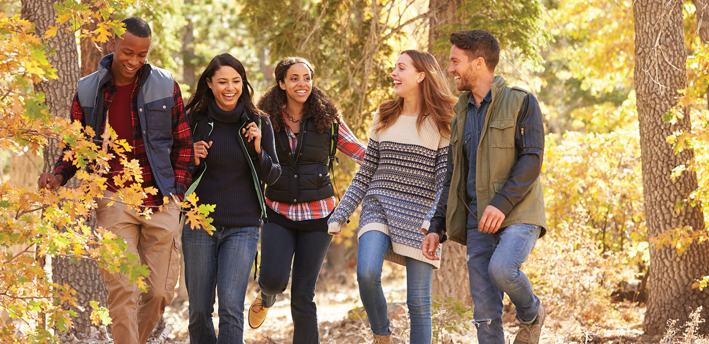 A group of young adults walking through the woods