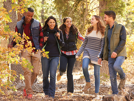 A group of young adults walking through the woods