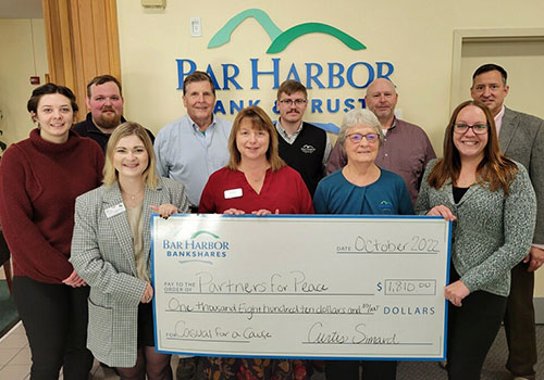 BHBT employees present a check to Partners for Peace