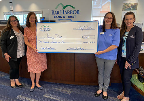BHBT employees present a check to People Plus