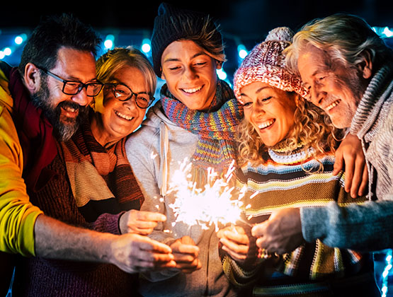 People smiling and lighting sparklers