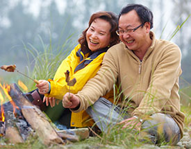 Couple roasting marshmallows over a fire