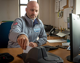 Image of man scanning a check at his desk