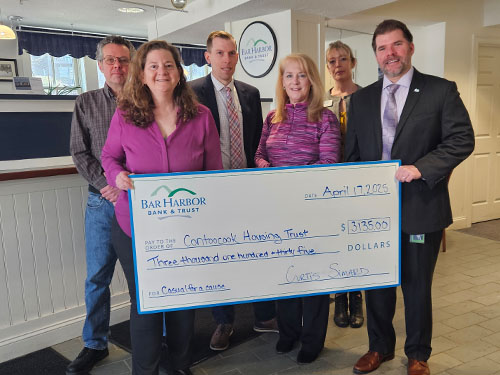 BHBT employees present a donation to Contooscook Housing Trust