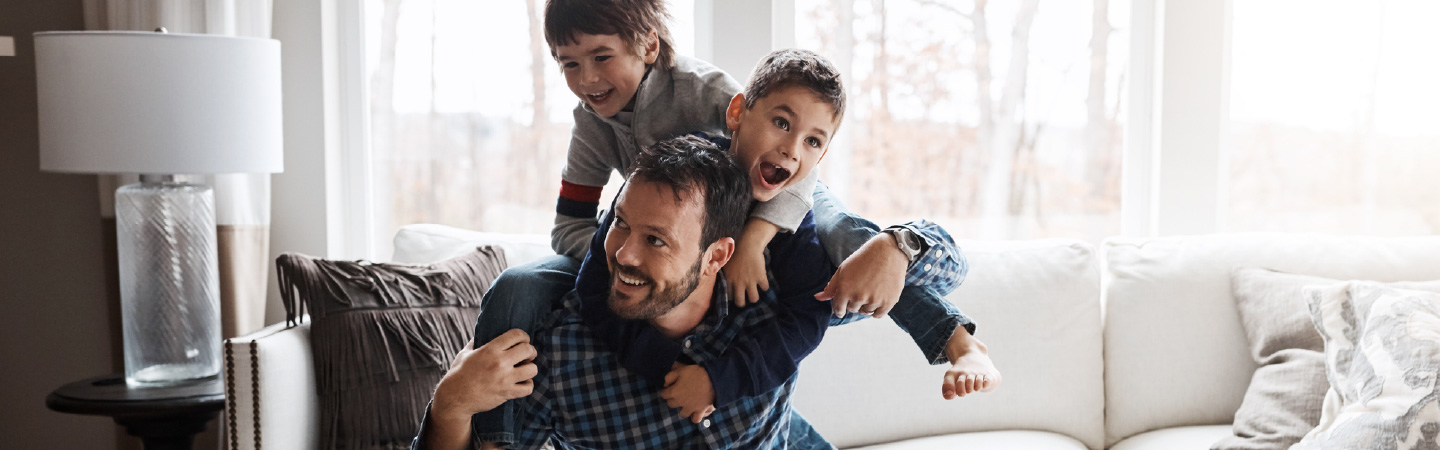 A young family playing together on a couch.