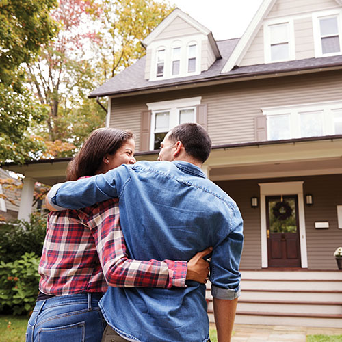 A couple walking to the front porch of their home