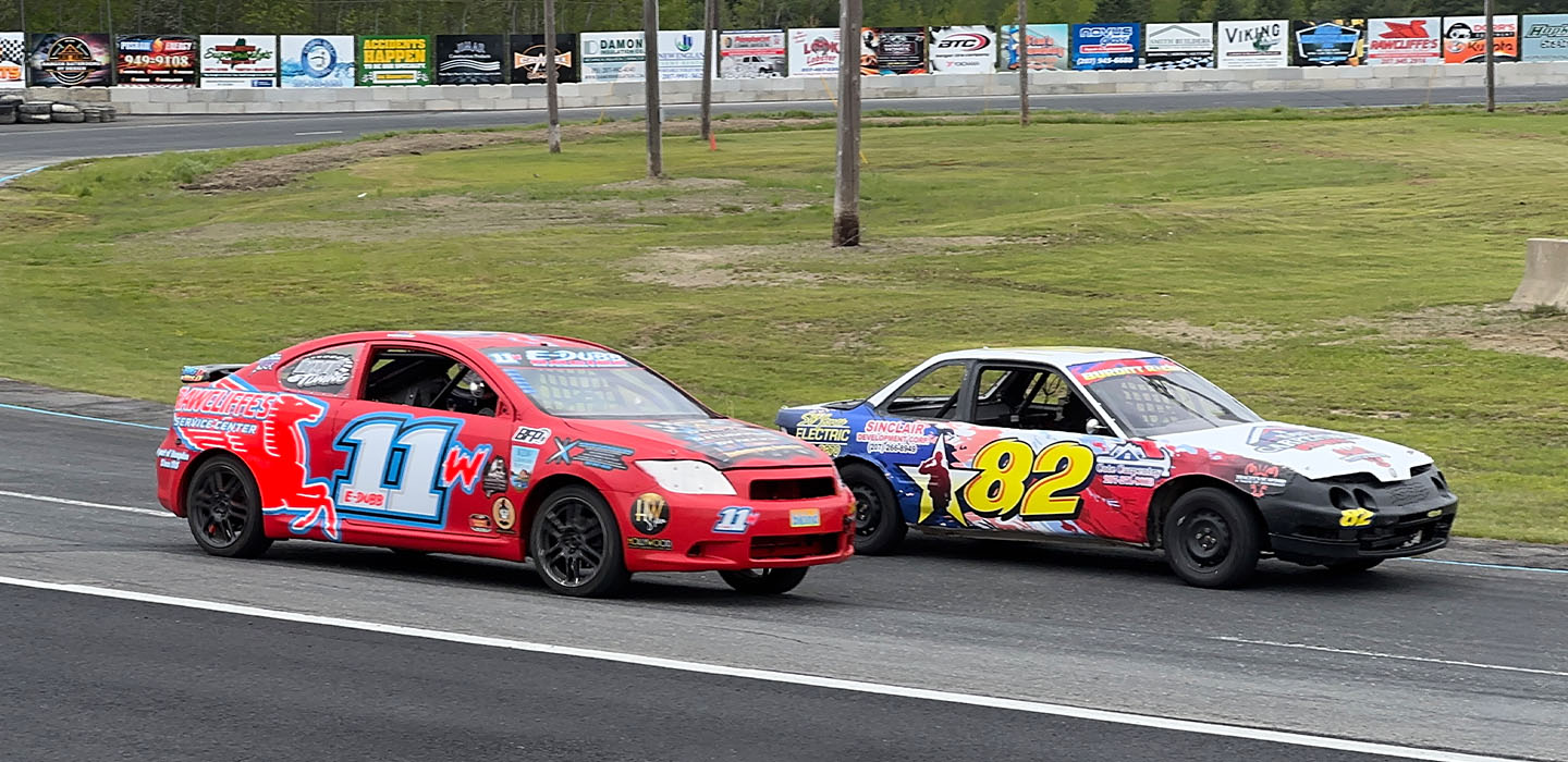 Two cars racing on the track at Speedway