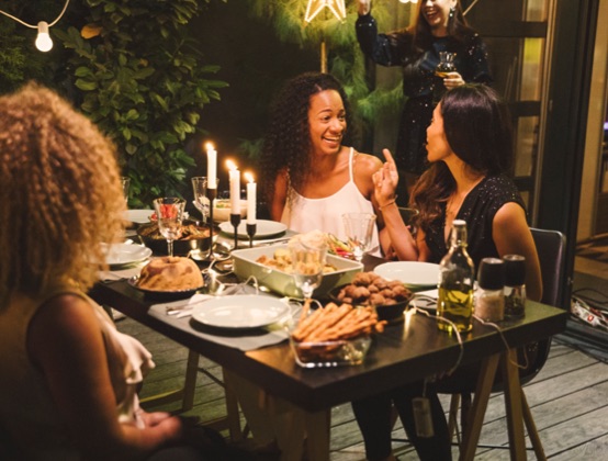 A group of people eating together outside at a party.