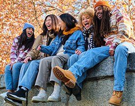 Friends laughing while surrounded by Fall foliage