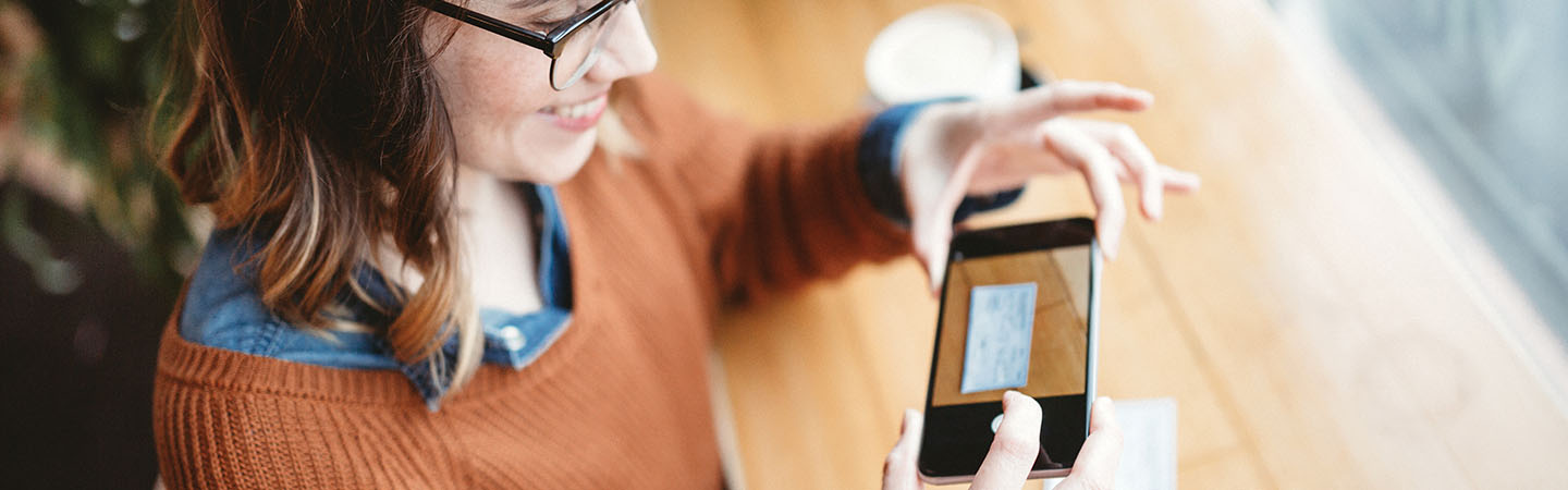 Woman taking an image of her check with her smartphone