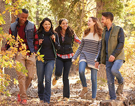 A group of young adults walking through the woods
