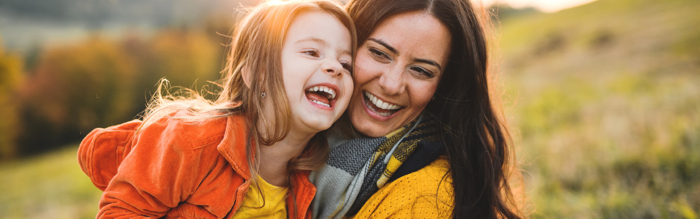 A mother and small child playing outdoors.