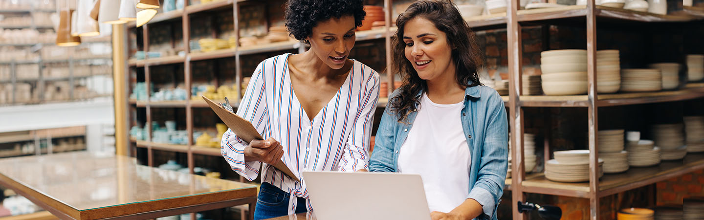 Two business owners looking at a laptop in their store